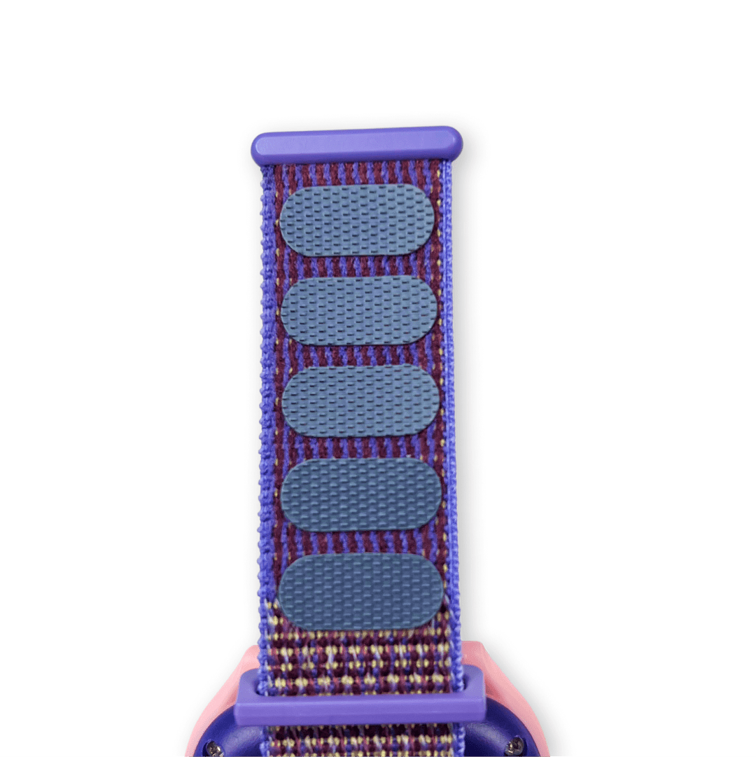 Fialový textilní řemínek s fialovýmisuchými zipy pro snadné nastavení délky, připevněný k chytrým hodinkám.